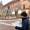 Bambino in piazza Maggiore con la mappa di Bologna di viaggiapiccoli