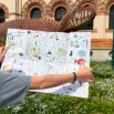 mappa di Milano per bambini aperta davanti al dinosauro del Museo di scienza Naturali